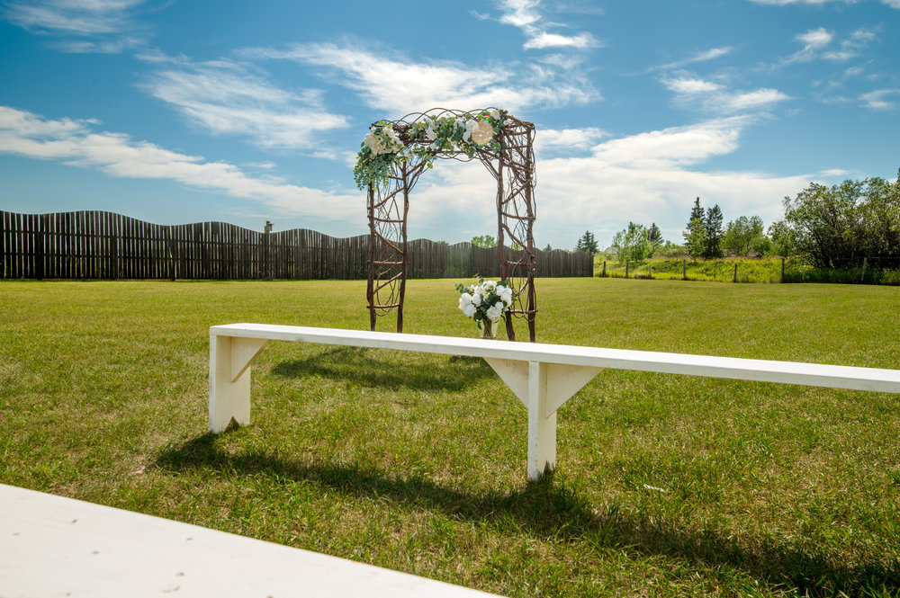 Wedding ceremony arch and benches on the lawn at Prairie Junction