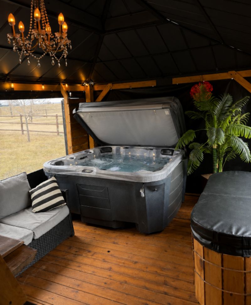 The enclosed hot tub inside the Prairie Junction spa hub with chandelier and lounge seating